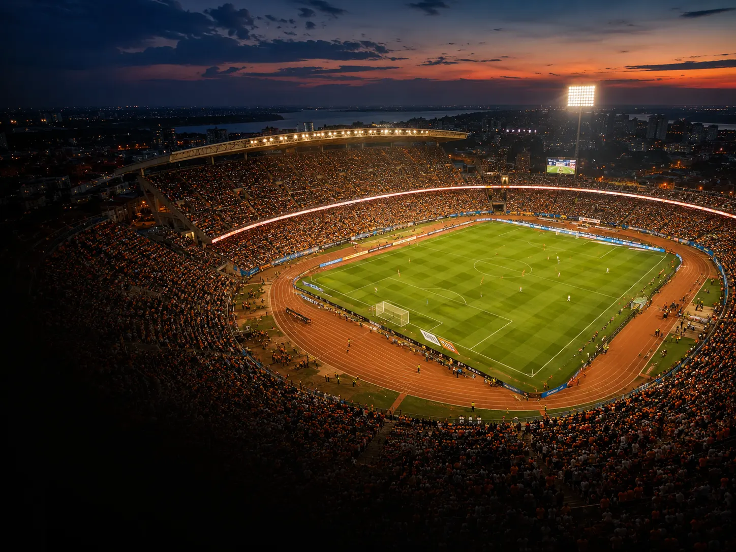 Stade de football illuminé au crépuscule, vu des tribunes